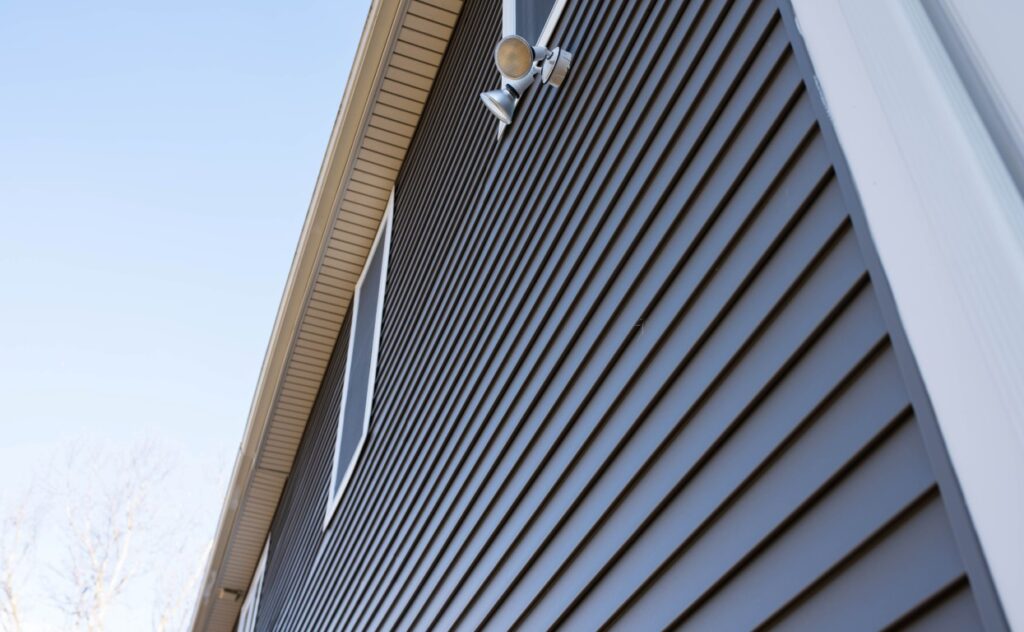 A closeup of the dark siding of a house seen from below.